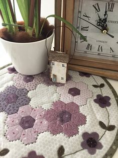 a potted plant sitting on top of a table next to a clock