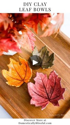 three leaf bowls sitting on top of a wooden cutting board with leaves in the background