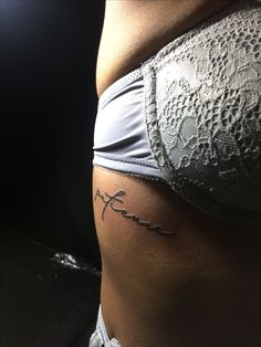 a woman's stomach with the word love tattooed on it