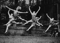 four young men are jumping in the air with their arms outstretched and legs spread out