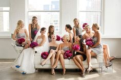 a group of women sitting on top of a white couch in front of a window