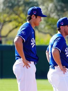 two baseball players standing next to each other on a field