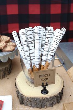 some cookies are in a glass vase on a table with other desserts and pastries