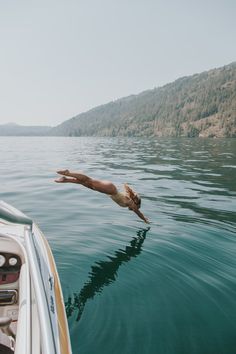 a person diving into the water from a boat