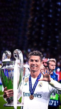 the soccer player is holding his trophy and posing for a photo with it's hands in the air