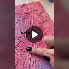 a woman is painting a pink flower with acrylic paint on her thumbnails