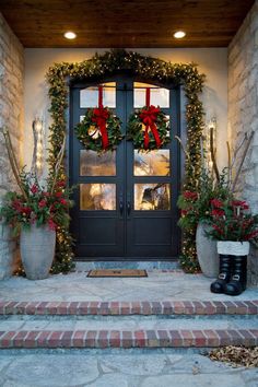 two christmas wreaths on the front door of a house