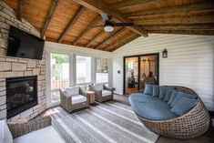 a living room filled with furniture and a flat screen tv mounted on the wall next to a fire place