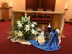 flowers and candles are placed on the floor in front of an altar