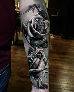 a black and white rose tattoo on the arm