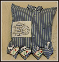 a blue and white striped pillow sitting on top of a bed next to two heart shaped pillows