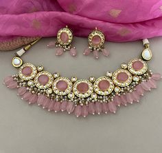 This beautiful pink kundan necklace set with earrings to match has great artistry and will add charm to your attire. It is embedded with kundan and pink stones. The dangling pink beads add a classic sparkle.  Details: Necklace Width-2 Inches Earrings Length-2 Inches Weight of Each Earring-14 gms All products are manufactured using traditional skills from our rich heritage of crafts.  The process of these crafts is essentially manual. Hence, any irregularities or variations are an inherent part of these handcrafting processes. Festive Pink Jewelry Sets, Festive Pink Round Jewelry Sets, Pink Kundan Necklace For Festivals, Pink Kundan Jewelry Sets, Pink Traditional Necklace With Stone Work, Traditional Pink Necklace With Stone Work, Traditional Pink Stone Work Necklaces, Pink Kundan Necklace For Gift, Pink Kundan Necklace As A Gift