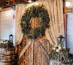 two wooden barrels with wreaths and lights on them