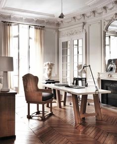 a living room filled with furniture and a fire place in the middle of a wooden floor