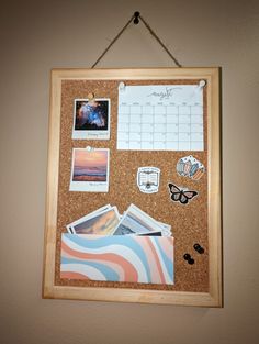 a cork board with pictures and magnets attached to it hanging on a white wall