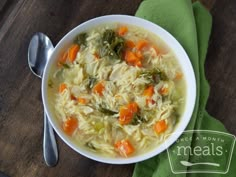 a bowl of chicken noodle soup with carrots and celery