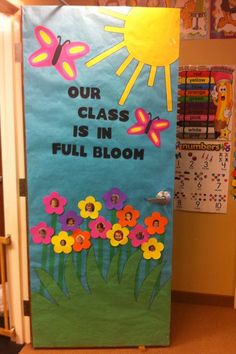 a classroom door decorated with flowers and butterflies for the class's full bloom day