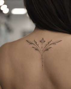 the back of a woman's shoulder with an intricate flower tattoo design on it