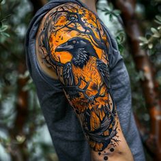 a man's arm with an orange and black tattoo design on it, featuring a crow