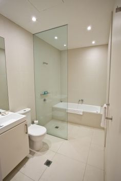 a bathroom with a toilet, sink and bathtub next to a shower stall in it