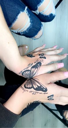 two women with tattoos on their hands and one has a butterfly tattoo on her arm