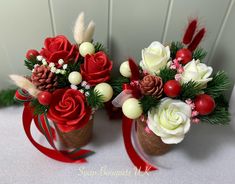 two vases filled with flowers and pine cones