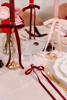 the table is set with candles, plates and silverware