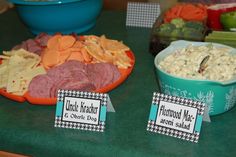 two bowls filled with food on top of a green counter next to plates full of food