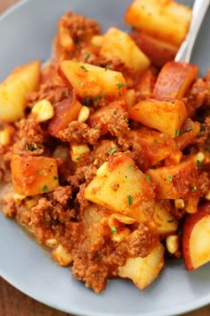 a blue plate topped with potatoes and meat