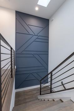 an empty room with some stairs and a wall painted in shades of blue, white and grey