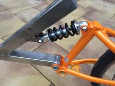 an orange bicycle with a large metal handlebar