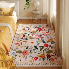 a white rug with flowers on it in a bedroom next to a bed and window