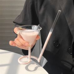 a person holding a glass with a drink in it and a stick sticking out of it