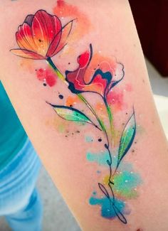 a watercolor tattoo with two flowers painted on it