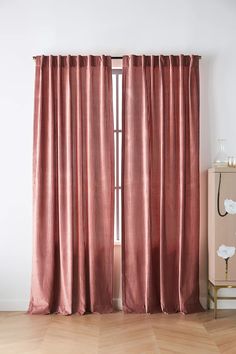 the curtains are closed and ready to be hung in front of an open window with wood floors