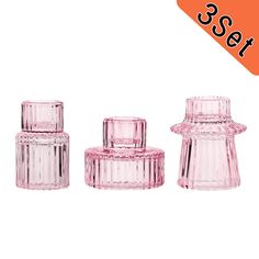 three pink glass jars with lids are shown