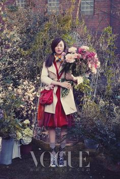 a woman in a red dress holding flowers