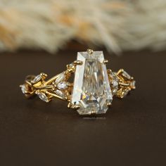 a close up of a ring with an oval cut diamond surrounded by smaller round diamonds