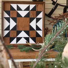 a wooden frame sitting on top of a table next to a potted pine tree