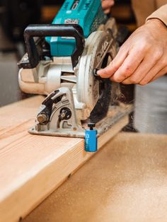 a person using a circular saw to cut wood with a cordless jig tool