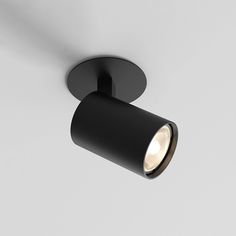 an overhead view of a black light fixture on a white wall with dim lighting in the corner