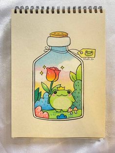 an open notebook with a drawing of a bird in a glass jar on it's cover