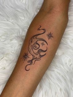 a woman's arm with a tattoo on it and stars in the sky above