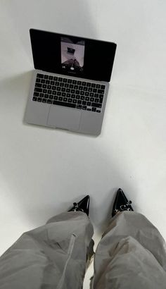 a person laying on the ground with their feet up in front of a laptop