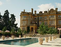 a large building with a pool in front of it and lots of trees on the other side