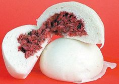 an open pita bread with meat inside on a red background, cut in half