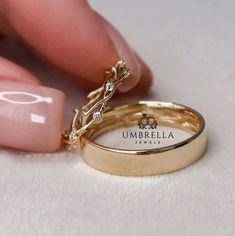 two gold wedding bands with diamonds on them are being held by someone's hand