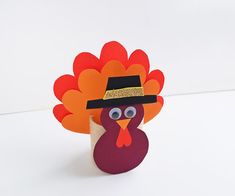 a paper turkey with a black hat on it's head is shown in front of a white background