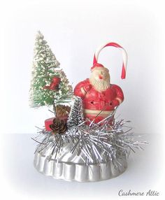 a santa clause figurine sitting on top of tinsel