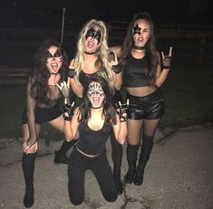 four women dressed in black posing for the camera with their faces painted to look like they are dancing